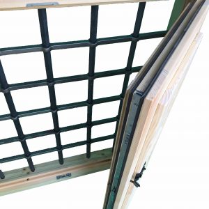 Imagen de una ventana de madera con reja. Destaca el detalle de cierre hermético y reja.